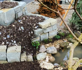 Verschiedene Klimazonen auf kleinem Raum: Erleben Sie die Perfektion ökologischer Gartengestaltung. Durch die Kombination von recycelten Natursteinen und einem kleinen Gewässer schaffen wir artenreiche Lebensräume und optimale Wachstumsbedingungen für Ihre Küchen- und Heilkräuter.